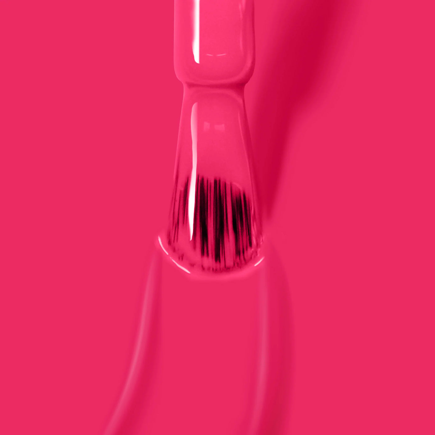 Close-up of a Queen of Hearts (Professional) nail polish brush from LONDONTOWN, showcasing bristles coated in the vibrant, cruelty-free deep fuchsia pink crème polish against a pink background—a perfect choice for your next party manicure.