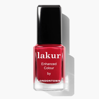 A bottle of LONDONTOWN Ring Me (Professional) red crème nail polish with enhanced color, featuring a glossy red shade, a black cap, and the Florium Complex for added benefits. This vegan, cruelty-free formula ensures a vibrant finish without compromising on ethics.