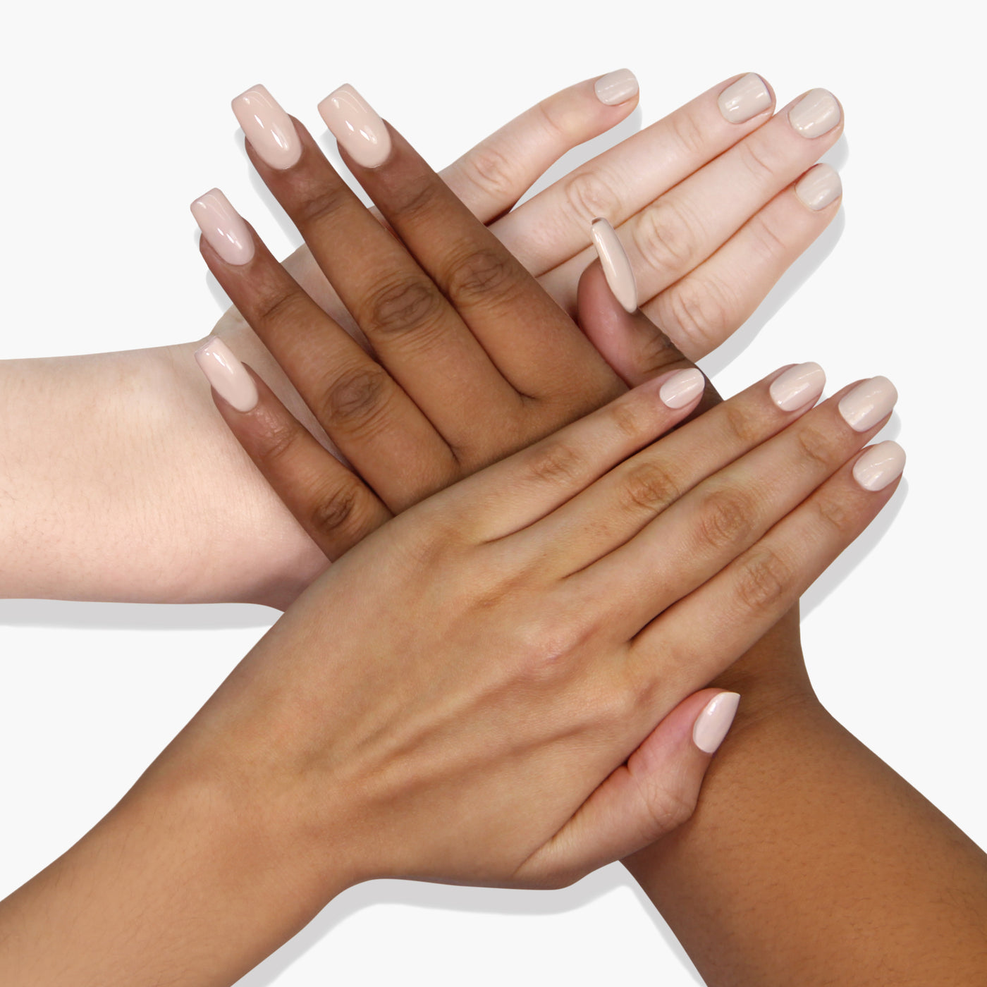 Four hands with different skin tones are stacked on top of each other, each adorned with LONDONTOWN's neutral-toned, vegan cruelty-free nail polish in the shade Sandstone.