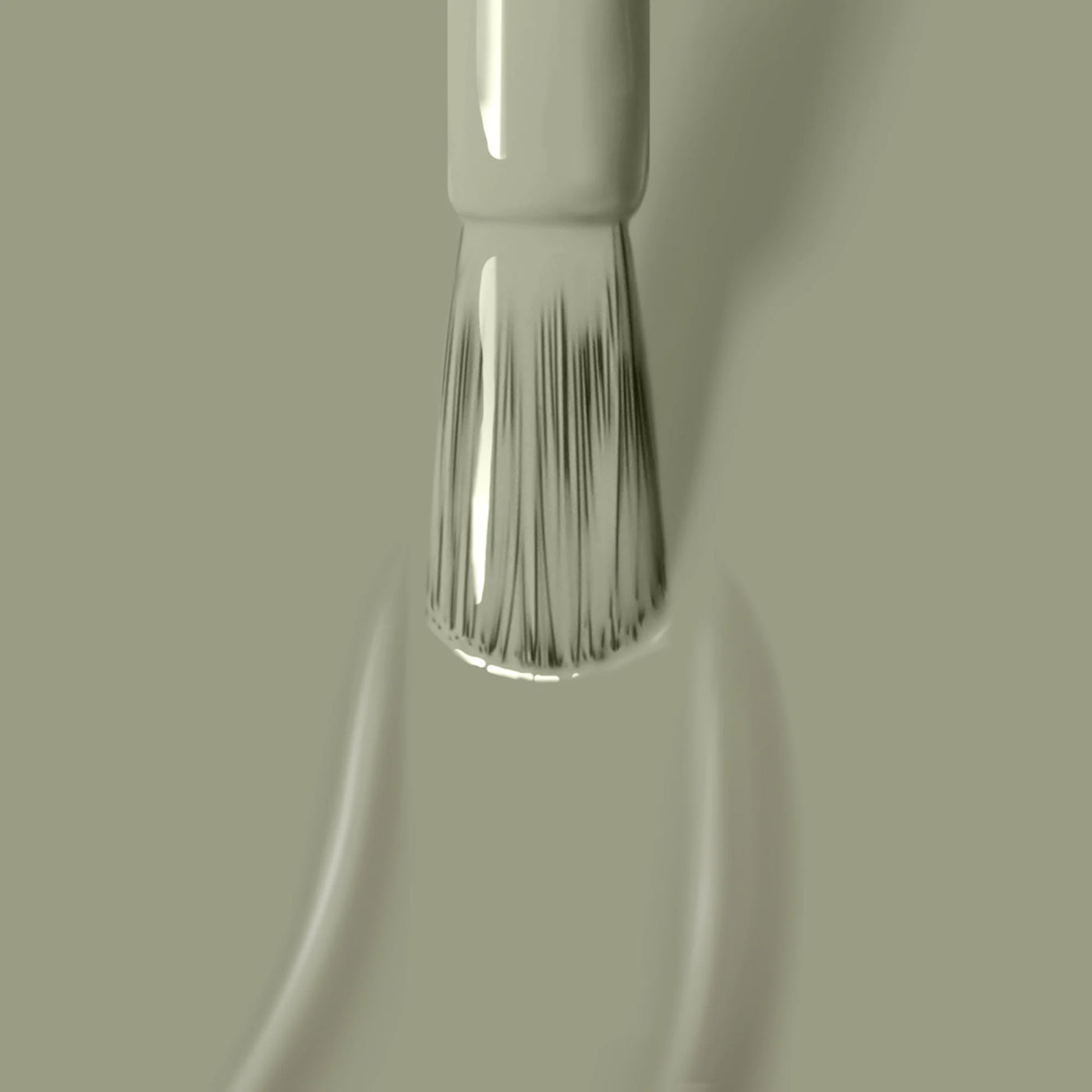 A close-up of a nail polish brush applying succulent Sedona jade green vegan cruelty-free nail polish from LONDONTOWN on a surface. The brush tips are slick with the glossy polish.