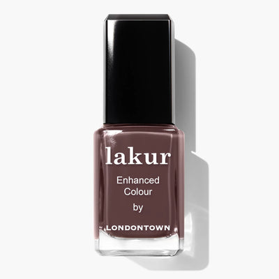 A bottle of LONDONTOWN Lakur nail polish in the shade "Teak (Professional)," a chocolatey brown color labeled as "Enhanced Colour." Infused with Florium Complex, this vegan and cruelty-free polish features a black cap and reflects light beautifully.