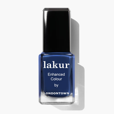 A bottle of LONDONTOWN Under the Stars lakur nail polish in a vintage denim deep blue color, labeled "Enhanced Colour.