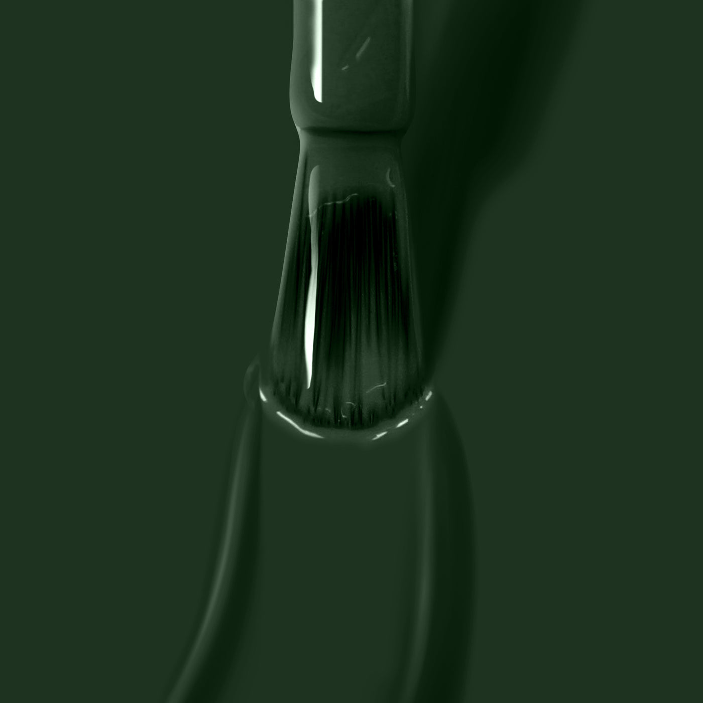 A close-up of a LONDONTOWN Vibe paintbrush bristle coated in jade green paint, with paint dripping off the brush like melted licorice.