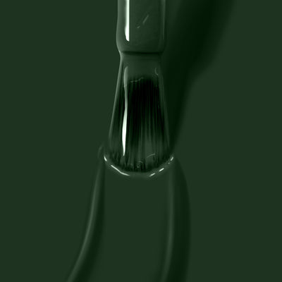 A close-up of a LONDONTOWN Vibe paintbrush bristle coated in jade green paint, with paint dripping off the brush like melted licorice.