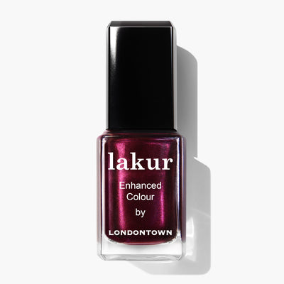 A bottle of LONDONTOWN Vixen nail polish with the label "Enhanced Colour." The polish is a decadent, deep, shimmery shade of burgundy.
