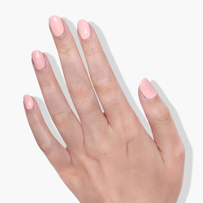 A hand with fingers spread, showcasing neatly manicured nails painted in LONDONTOWN's Waterloo Sunset, a light pink UV/LED Gel Color with a high-shine formula, set against a plain white background.