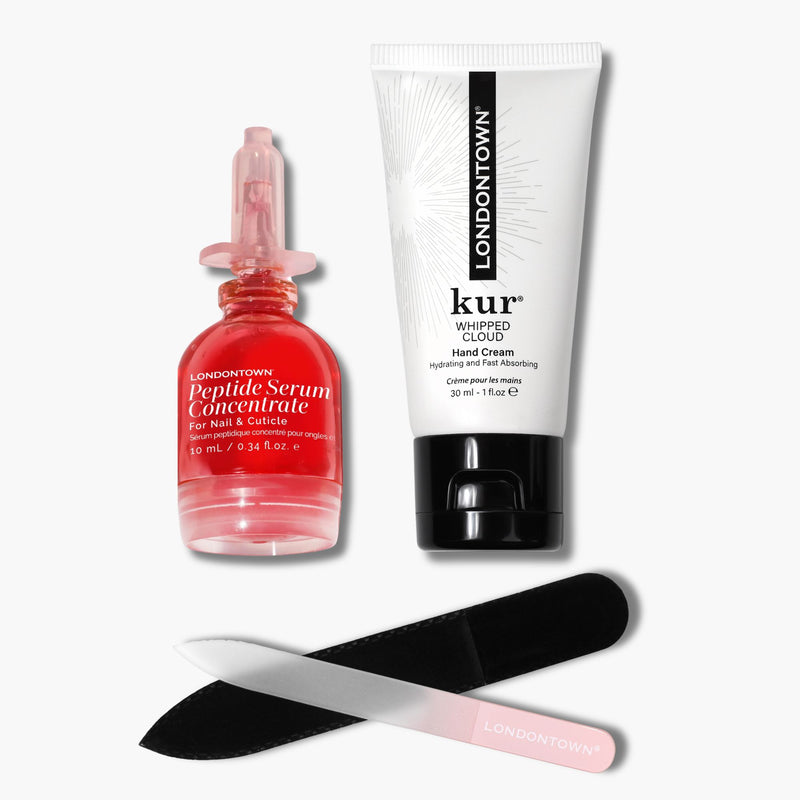 LONDONTOWN's Peptide Nail Repair Set includes a peptide serum, hand cream, glass nail file, and black emery board—all displayed on a white background for healthy-looking nails.