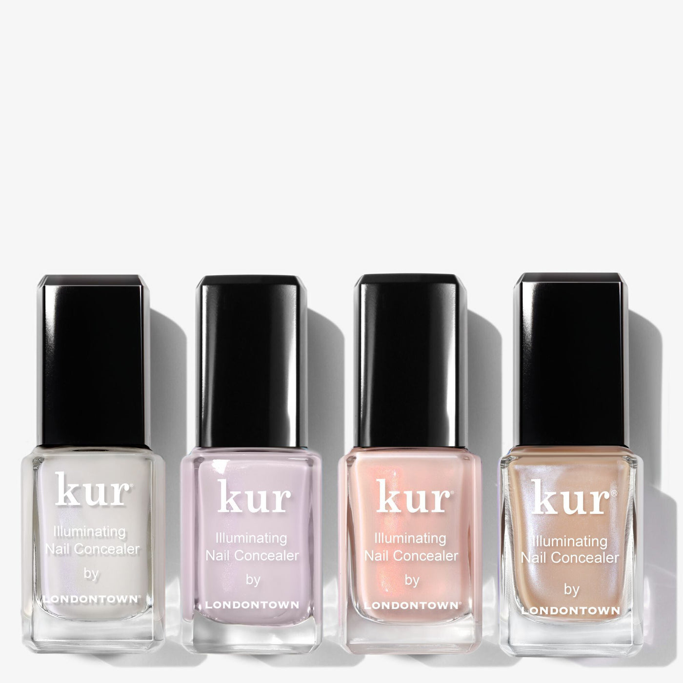 Four bottles of LONDONTOWN’s The Concealer Wardrobe are arranged in a row, each showcasing a different shade in clear glass bottles with sleek black caps for effortless nail perfection.