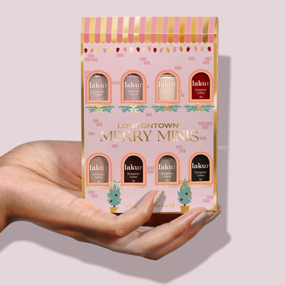 A hand holds a pink box labeled "LONDONTOWN Merry Minis Set," featuring eight assorted mini nail polishes displayed in individual arched windows.
