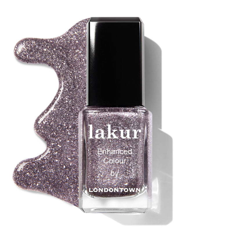 A bottle of LONDONTOWN Midnight Frost Duo nail polish in shimmery lavender with spilled polish beside it.