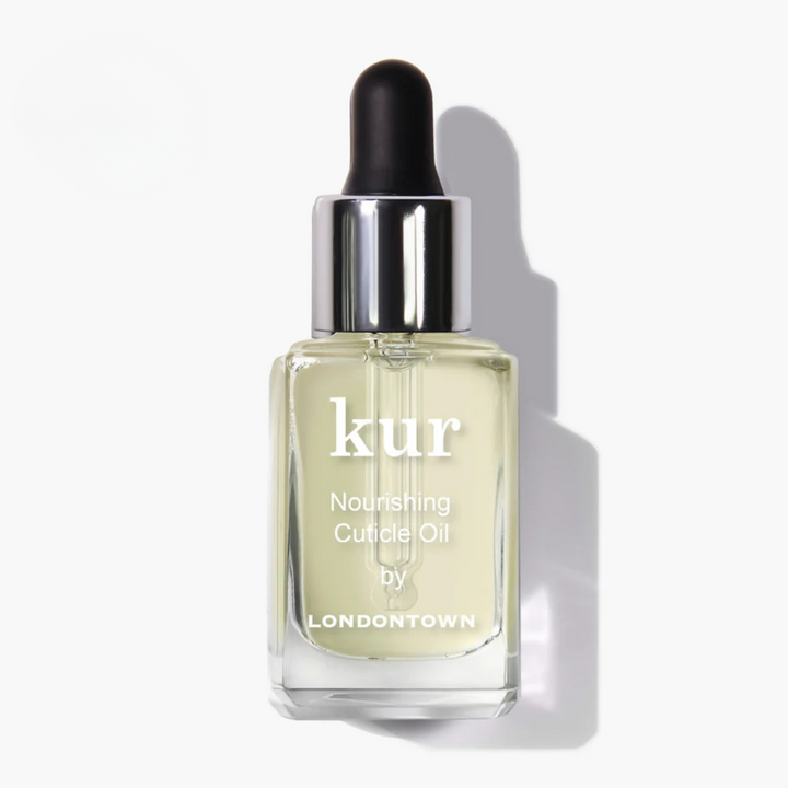 A glass bottle of LONDONTOWN Nourishing Cuticle Oil with pale yellow liquid, a black dropper top, and a printed label.