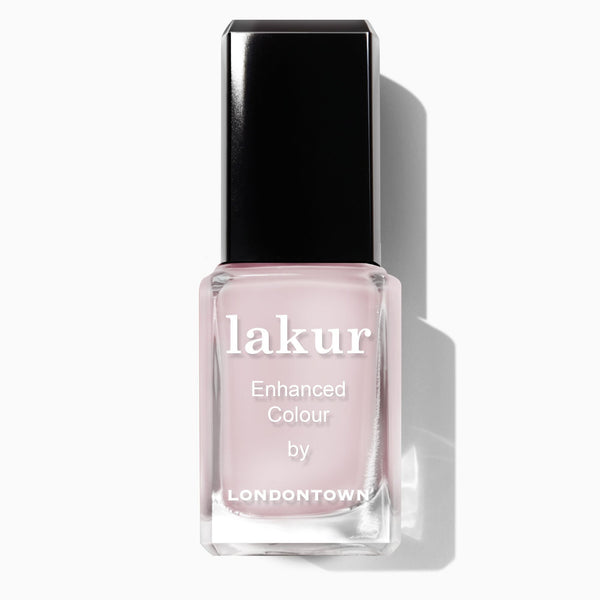 A clear glass bottle of LONDONTOWN Lakur Enhanced Colour nail polish in Strawberry Milk, featuring a sweet, milky pink shade and a black rectangular cap.