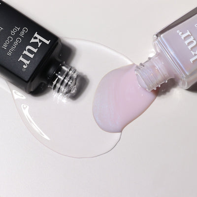 An opened LONDONTOWN Conceal & Go - Pink: Holiday Edition nail polish lies next to a black bottle, their spilled colors mingling on the surface—evoking flawless nails and mindful nail care.
