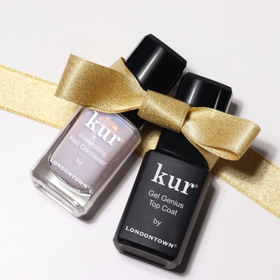 Two bottles of LONDONTOWN nail products—Conceal & Go - Pink: Holiday Edition and Gel Genius Top Coat—tied with a gold ribbon for effortless nail care and a flawless holiday-ready manicure.