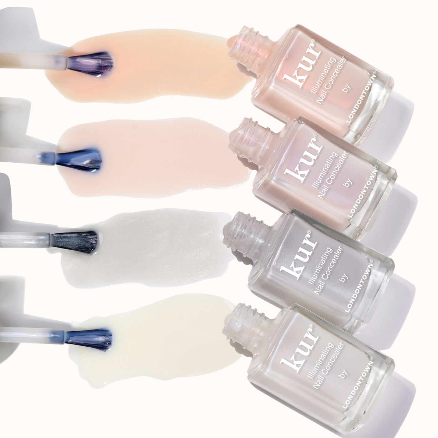Four open bottles of LONDONTOWN The Concealer Wardrobe, each displaying a different polish shade swiped on a light background—perfect for easy, one-step flawless nail care.