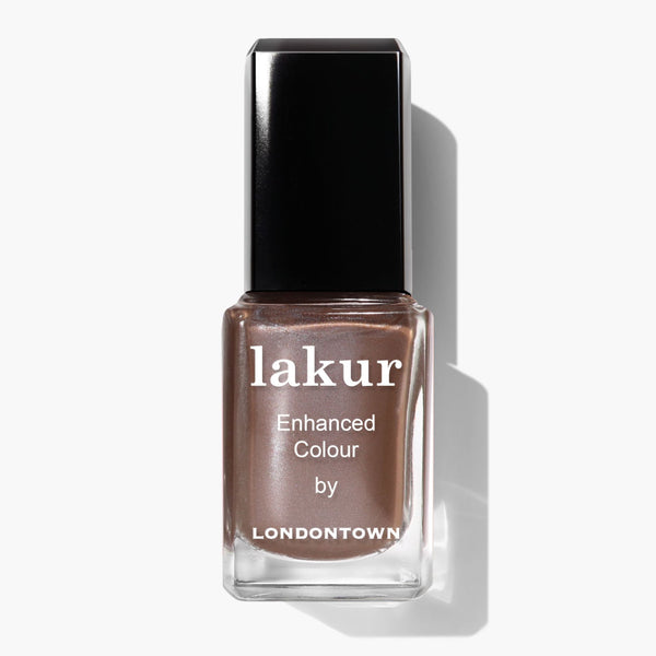 A bottle of LONDONTOWN Lakur nail polish in the shade "Affogato," a shimmering java glow metallic taupe, with a black cap, is displayed against a white background.
