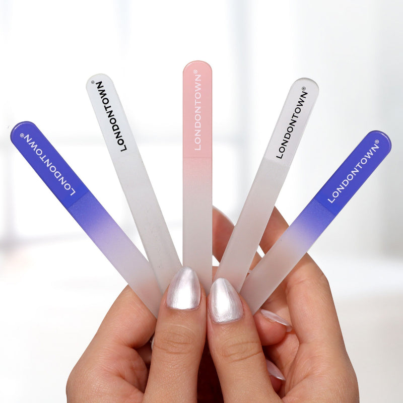 Person holding five Glass Nail Files - Lilac by LONDONTOWN, each displaying the brand name; these effortless nail files feature a gradient of blue, pink, and purple colors.