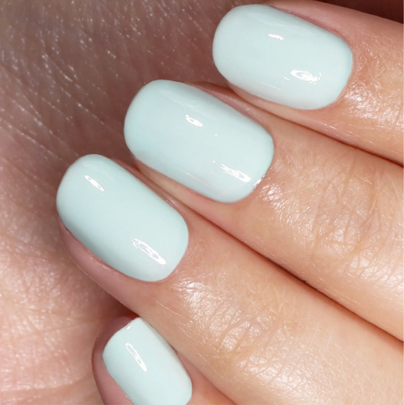 Close-up of a hand with short, neatly manicured nails painted in LONDONTOWN’s Beary Minty, an airy and glossy pale blue that evokes hopeful clarity.