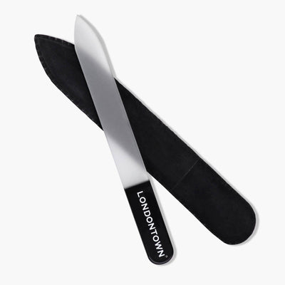 The "LONDONTOWN" Glass Nail File - Black, featuring a sleek black handle, is accompanied by a matching black protective sleeve to provide an effortless and damage-free nail filing experience.