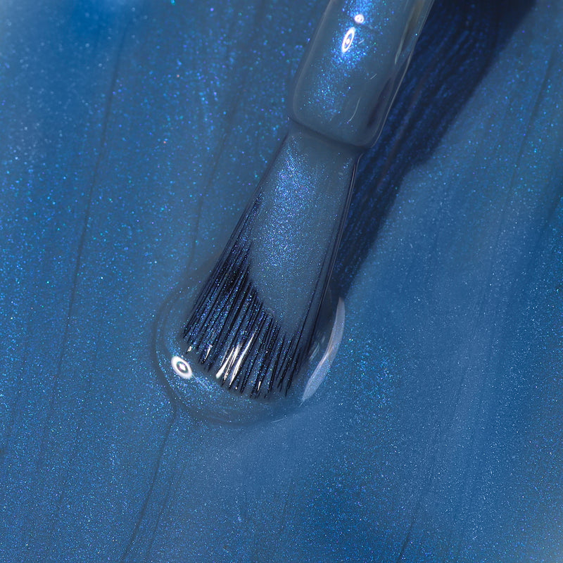 Close-up of a LONDONTOWN Blue Diamond nail polish brush applying sporty, shimmery blue nail polish with a glossy finish.