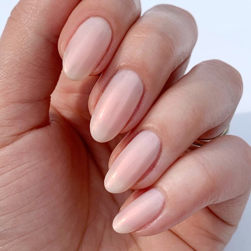 Close-up of a hand perfectly manicured with LONDONTOWN's Conceal + Go Bubble, showcasing naturally perfect nails in a subtle, natural pink shade against a plain background.