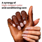 Two hands with polished nails in LONDONTOWN's "Champagne in Bed" soft neutral pink are shown. One has a square shape, the other an almond shape. Text reads, "A synergy of high-impact color and conditioning care, with a hint of holographic sparkle.