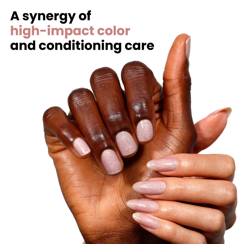 Two hands with polished nails in LONDONTOWN's "Champagne in Bed" soft neutral pink are shown. One has a square shape, the other an almond shape. Text reads, "A synergy of high-impact color and conditioning care, with a hint of holographic sparkle.