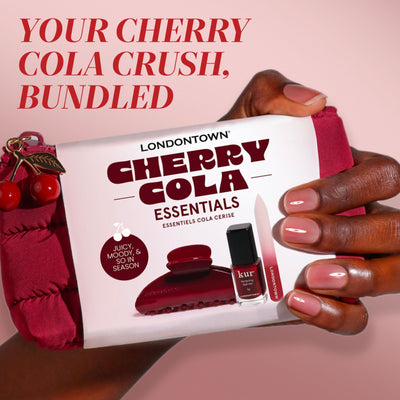 A hand holds LONDONTOWN's Cherry Cola Essentials pouch, bundled with nail polish and manicure tools, featuring the text "Your Cherry Cola Crush, Bundled.