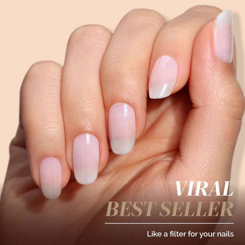 A hand with flawlessly manicured nails is shown against a beige background, featuring the text “Conceal + Go: Holiday Edition by LONDONTOWN—Viral Best Seller. Like a filter for your nails” in the bottom right corner.