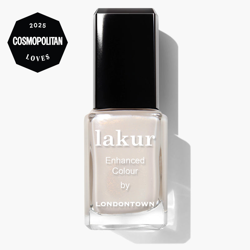 A bottle of LONDONTOWN Princess Awaits Lakur Enhanced Colour nail polish in a sheer white shimmer finish, featuring a 2025 Cosmopolitan Loves badge in the top left corner.