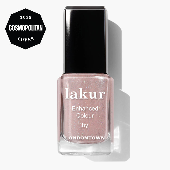 A bottle of LONDONTOWN Champagne in Bed Lakur Enhanced Colour nail polish in a neutral pink shade, featuring a 2025 Cosmopolitan Loves badge in the corner.