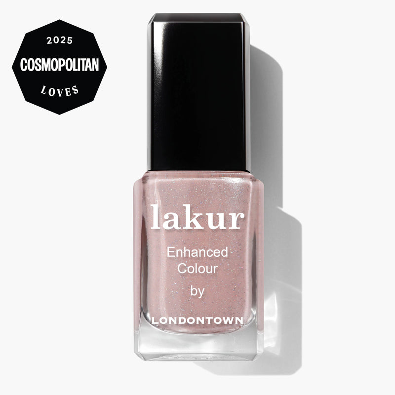 A bottle of LONDONTOWN Champagne in Bed Lakur Enhanced Colour nail polish in a neutral pink shade, featuring a 2025 Cosmopolitan Loves badge in the corner.