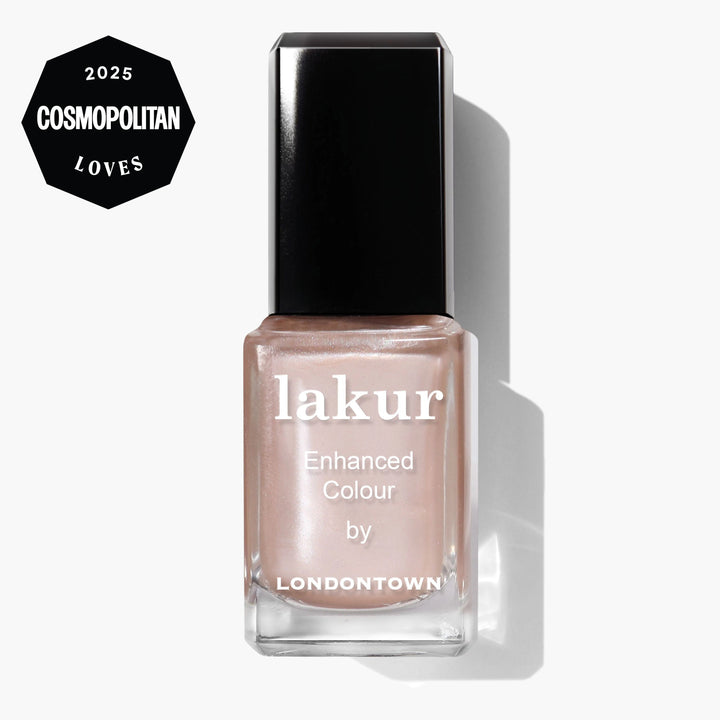 A bottle of LONDONTOWN Lakur Enhanced Colour nail polish in the Cold Foam shade—a light nude, whipped pearl—displaying a "2025 Cosmopolitan Loves" badge in the top left corner.