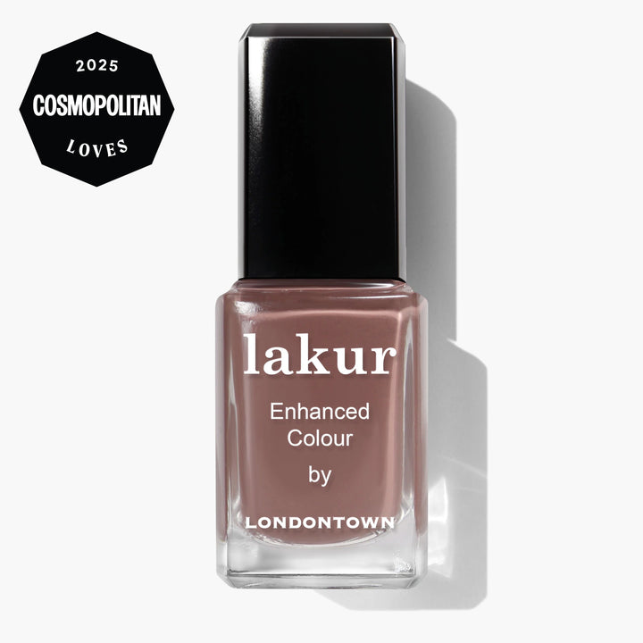 A bottle of LONDONTOWN Dirty Chai Lakur Enhanced Colour nail polish in mauve spiced brown, with a "2025 Cosmopolitan Loves" badge in the top left corner.