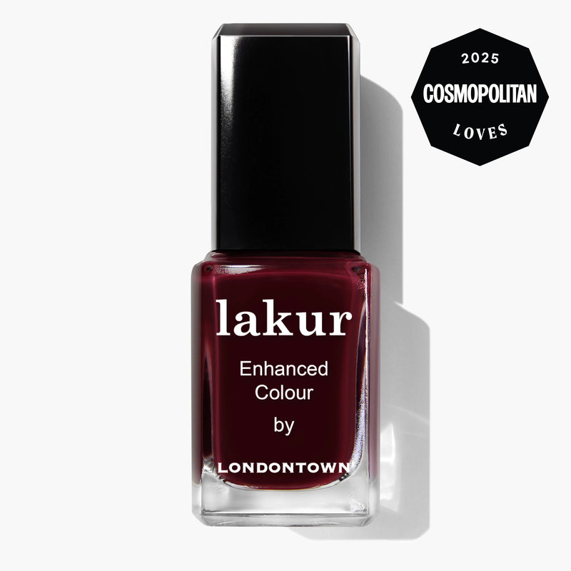 A bottle of LONDONTOWN Lakur Enhanced Colour nail polish in Naughty List (deep burgundy), with a "2025 Cosmopolitan Loves" badge in the top right corner.