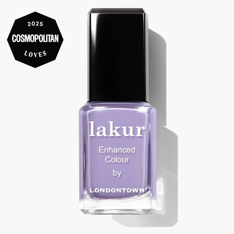 A bottle of LONDONTOWN Trolley Away Lakur Enhanced Colour nail polish in light purple, featuring a "2025 Cosmopolitan Loves" badge. This vegan, cruelty-free polish delivers vibrant, lasting color.