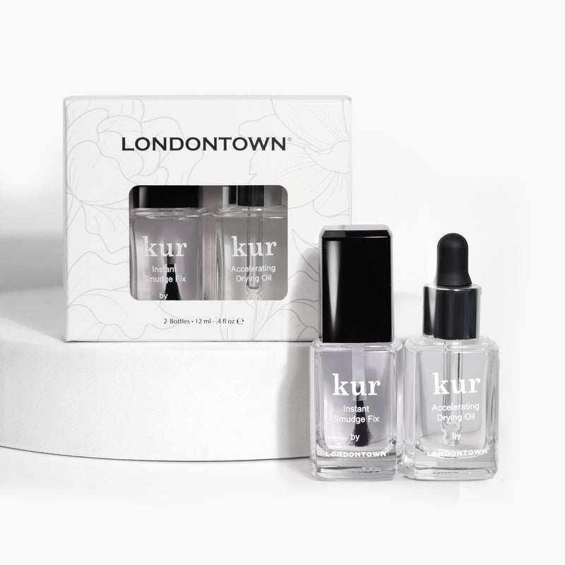 Two bottles of LONDONTOWN's S.O.S. Salon Staples, including Instant Smudge Fix and Accelerating Drying Oil, are displayed next to their packaging. Discover salon secrets for a perfect mani with these fast-drying essentials.