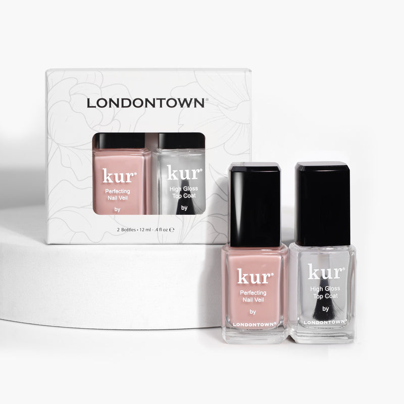 Two bottles of LONDONTOWN nail polish, one labeled "Tint & Shine: #4" in sheer light pink and the other "High Gloss Top Coat" offering high shine, with the packaging box placed behind them.