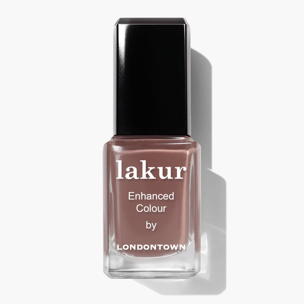 A bottle of LONDONTOWN Lakur Dirty Chai nail polish features a square black cap and shows spiced brown taupe color inside.
