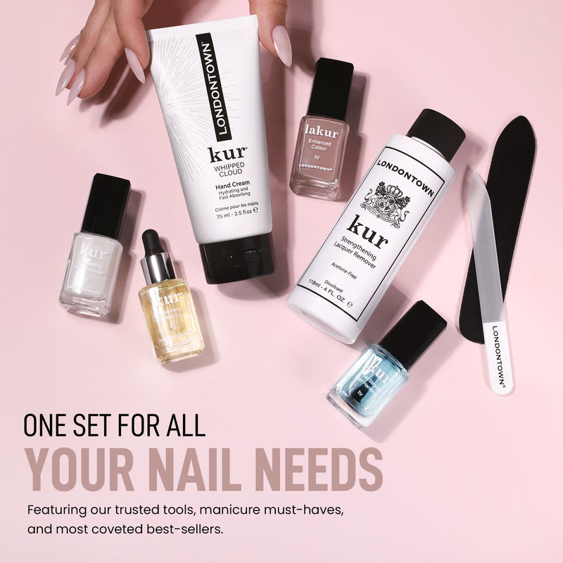A hand reaches for the Londontown Discovery Set 2.0 by LONDONTOWN, featuring creams, polishes, a nail file, and oil—spotlighting key nourishing and protective benefits—arranged on a pink background with promotional text.