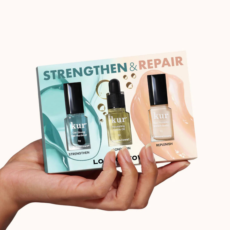 A hand holds a LONDONTOWN Strengthen & Repair Trio box, displaying three nail care products through clear cutouts—designed to restore and fortify weak nails.