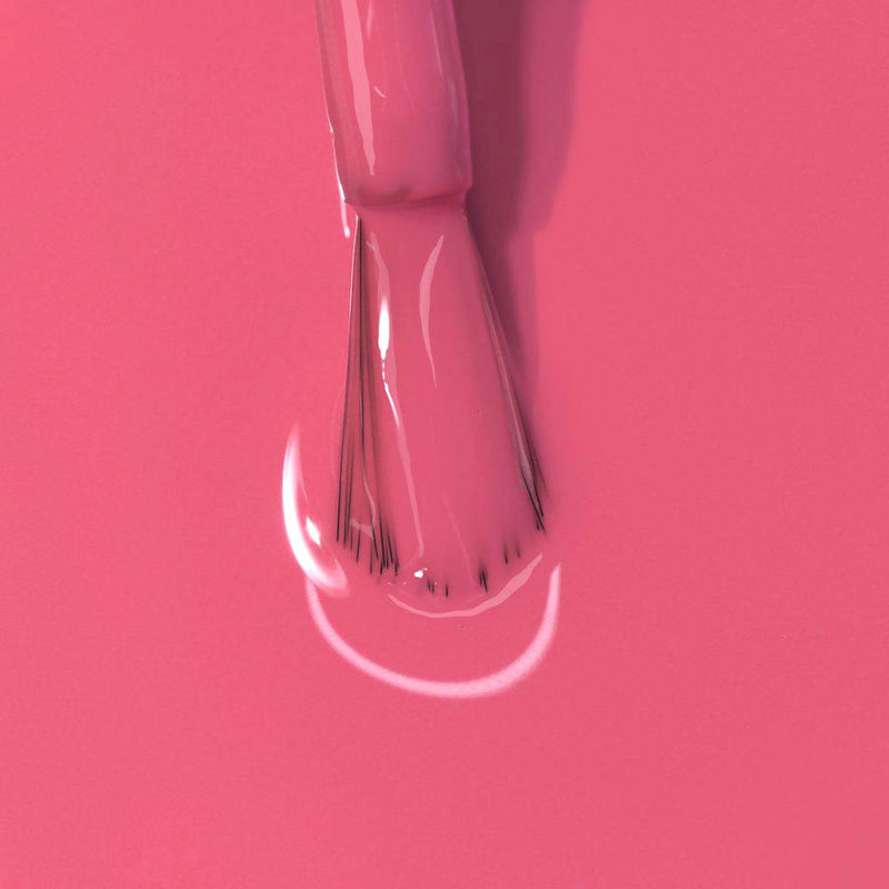 Close-up of LONDONTOWN's Electric Flamingo nail polish being applied with precision on a smooth surface.