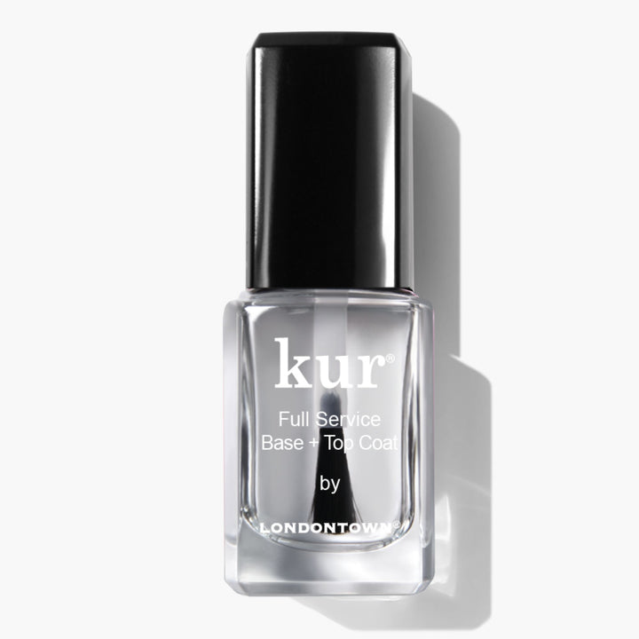 A clear bottle of LONDONTOWN Full Service Base + Top Coat nail polish with a black cap is shown on a white background—this all-in-one formula provides shine and protection in one step.