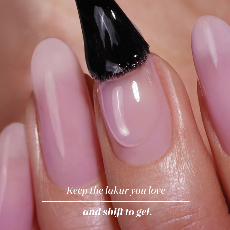 A close-up of a hand with pink nails as a brush applies LONDONTOWN GelShift Top Coat. Text: "Keep the lakur you love and switch to an at-home gel mani—just cure under UV/LED.