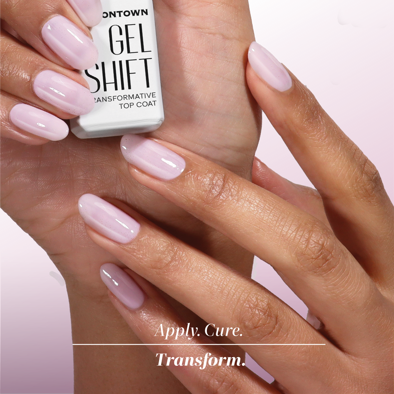 A hand holds a LONDONTOWN GelShift Kit, while the other shows glossy light pink nails. Text reads: "Apply. Cure. Transform." Instantly transform your manicure with this essential gel polish kit.