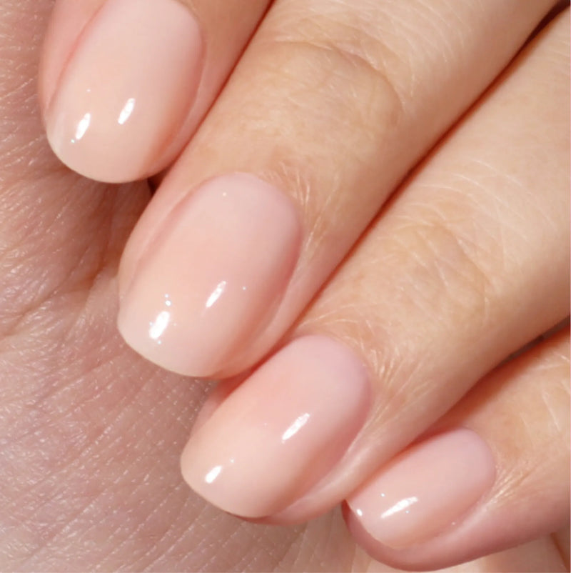 A close-up of a hand with neatly manicured nails painted in LONDONTOWN's Good Vibes Only, a glossy sunlit peach shade that creates a warm, inviting look.