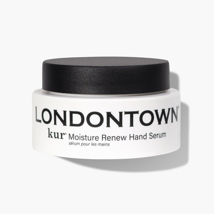 A jar labeled "Moisture Renew Hand Serum" from LONDONTOWN, featuring a white container and black lid, promises to be the restorative rescue for even the driest hands.