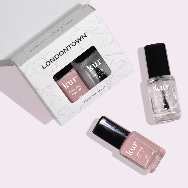The LONDONTOWN's Tint & Shine: #4 nail polish set, featuring a conditioning lacquer and high gloss top coat in rectangular bottles with black caps, is showcased on a light surface with soft shadows. This set provides moisturizing care and sheer color for a flawless finish.