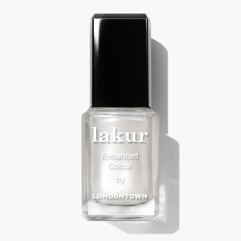 A bottle of LONDONTOWN Lakur nail polish with a black cap and a white label reading "lakur, Enhanced Colour by LONDONTOWN." The polish is in the shade Powder.