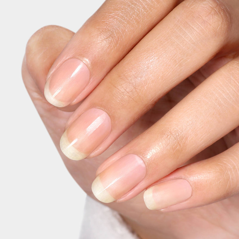 A close-up of a hand with neatly manicured, polish-free nails shows their natural shine and buffed finish achieved using LONDONTOWN Smooth & Shine Buffer Pads against a light background.